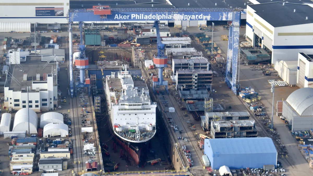 A vessel under construction beneath shipyard cranes at Philadelphia Shipyard